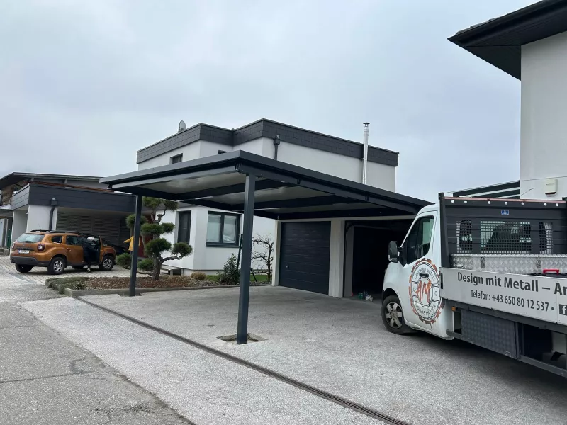 Modernes Carport vor zwei Garagen