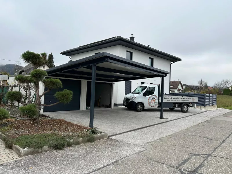 Modernes Carport vor zwei Garagen